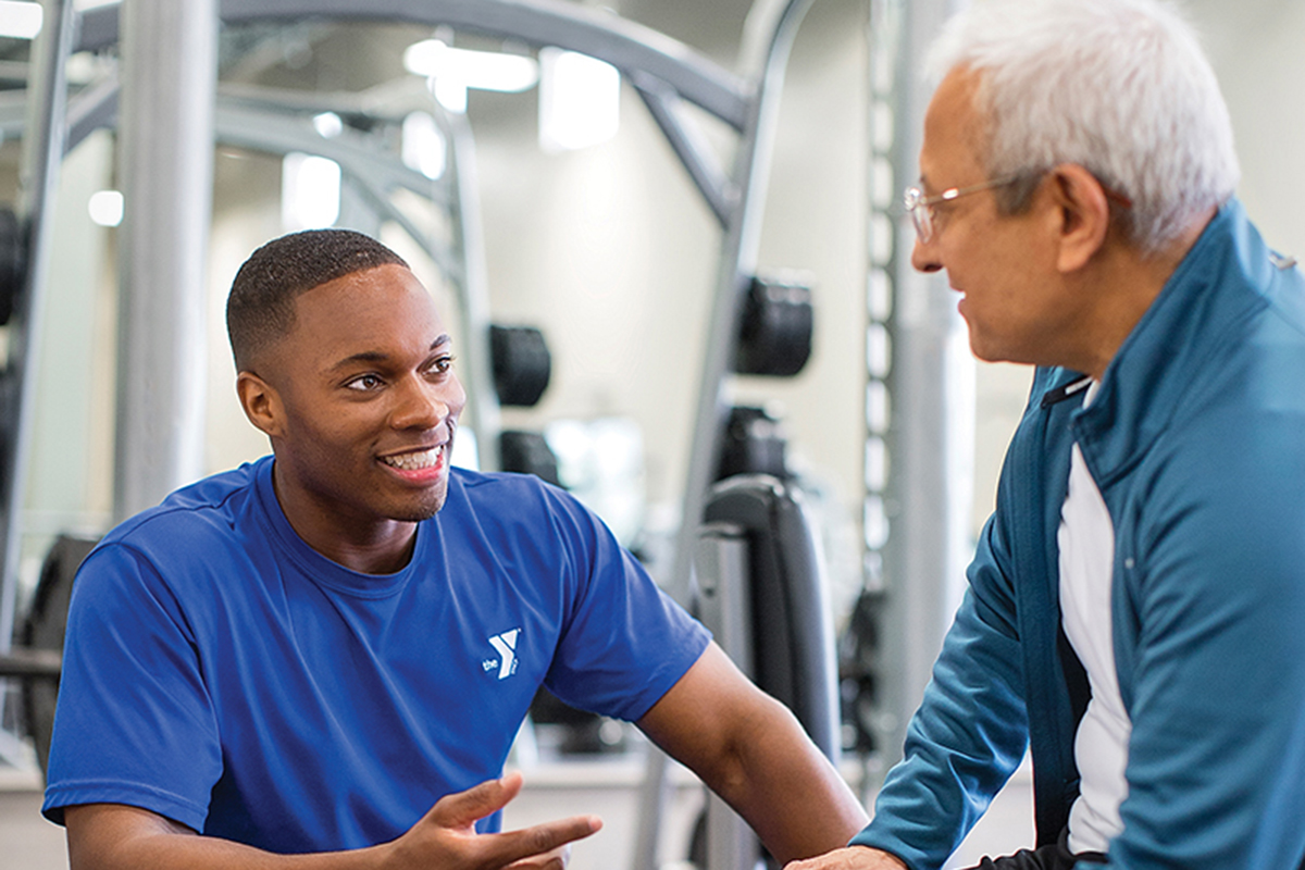 Personal trainer helping client.